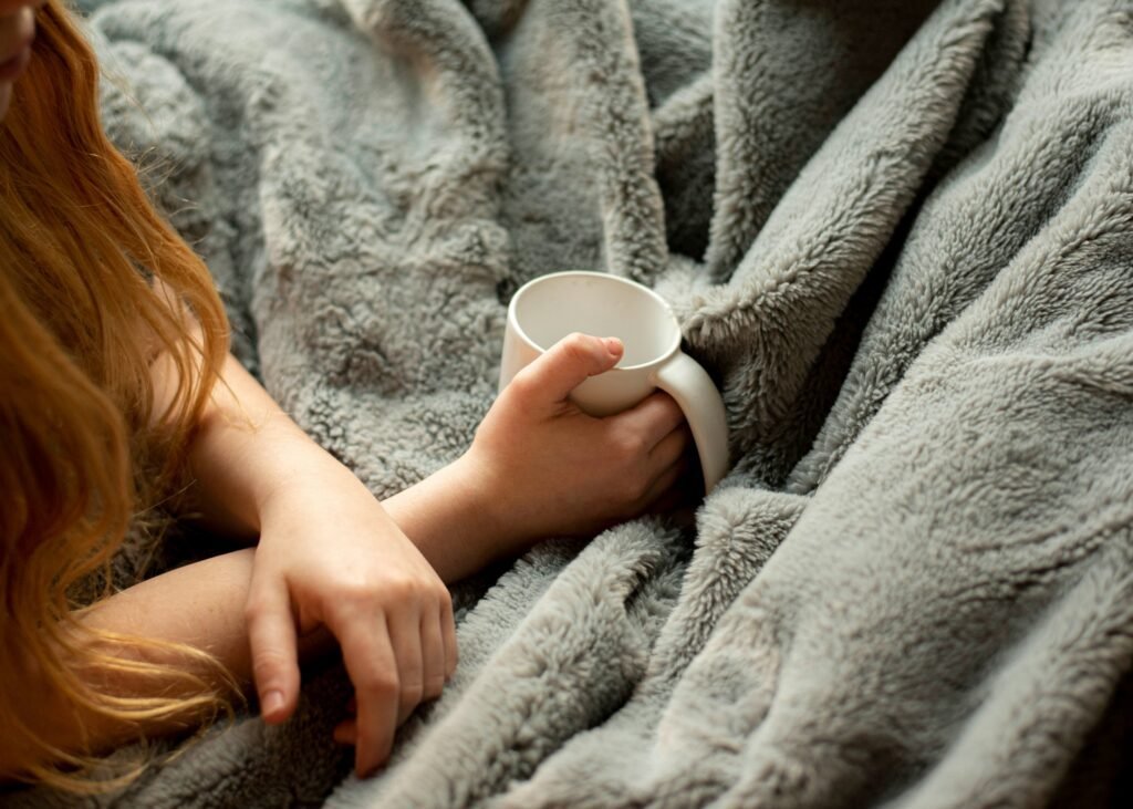 a plush blanket and a woman holding a coffee mug 