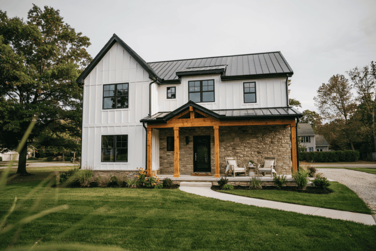 modern farmhouse exterior with chairs on the front porch, and a manicured lawn