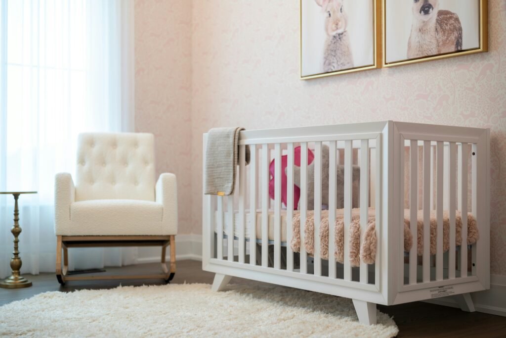 nursery bedroom with a crip and comfortable chair paintings of rabbits on the wall above the crib
