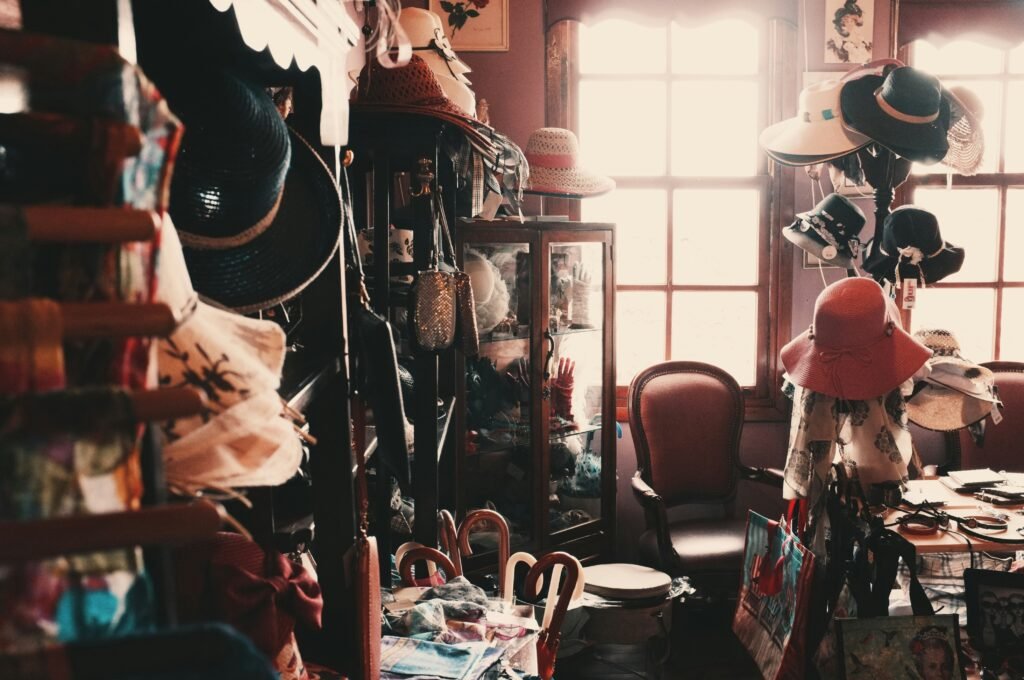 a room in a house a a chair, lots of hats and a lot of clutter
