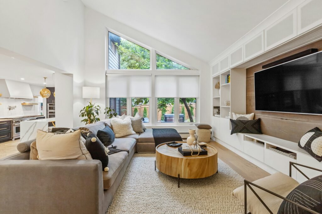 organic modern interior design with large television on he wall and multiple pillows arranged 