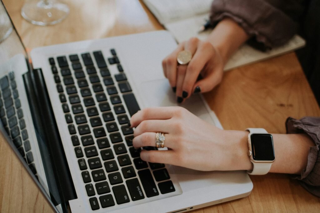 a women's hands typing on a laptop 
